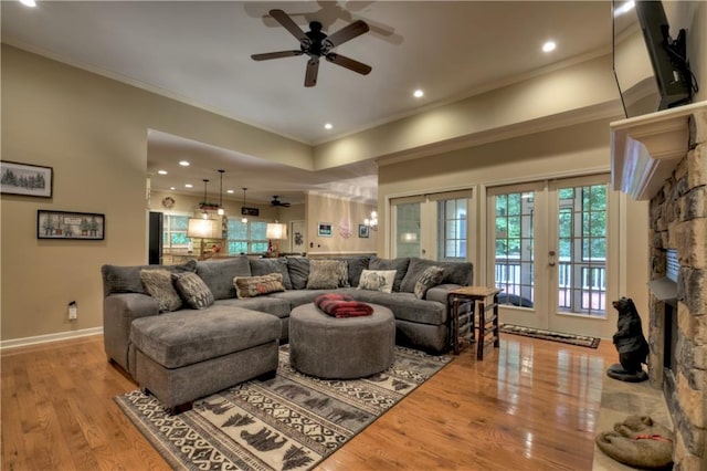 living room with a fireplace, french doors, ceiling fan, and light hardwood / wood-style floors