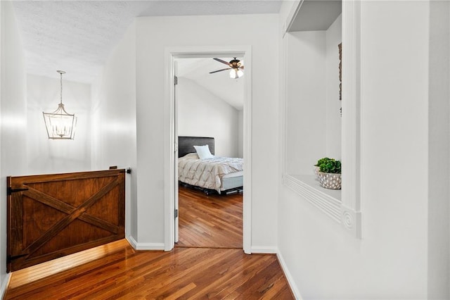 bedroom with a ceiling fan, wood finished floors, a textured ceiling, baseboards, and visible vents