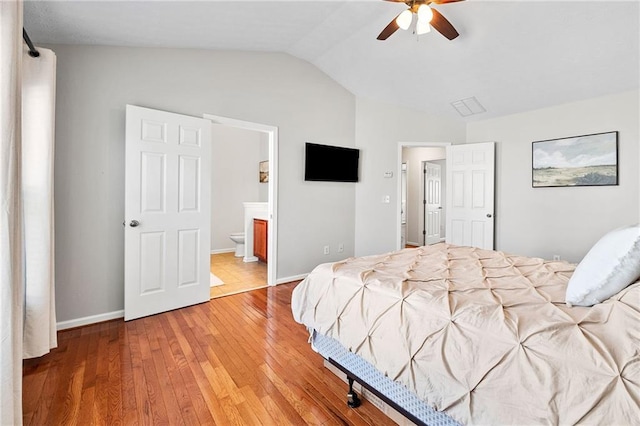 bedroom featuring connected bathroom, a ceiling fan, lofted ceiling, light wood-style flooring, and baseboards