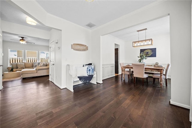 dining space featuring a ceiling fan, wood finished floors, visible vents, and crown molding