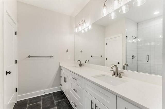 bathroom with a shower with door, vanity, and tile patterned floors