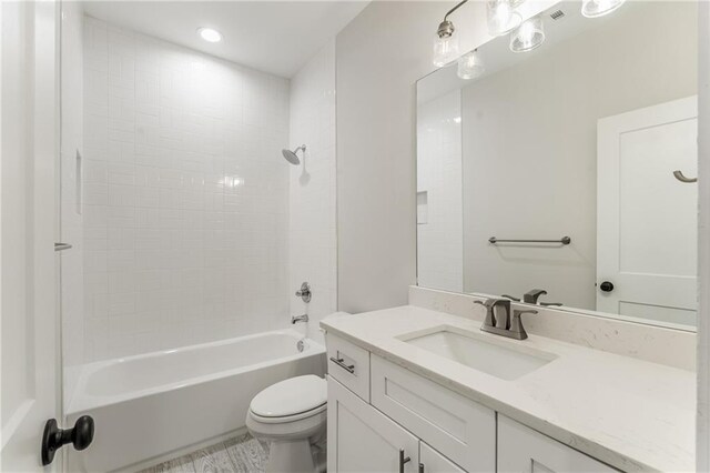 full bathroom with vanity, toilet, and tiled shower / bath combo