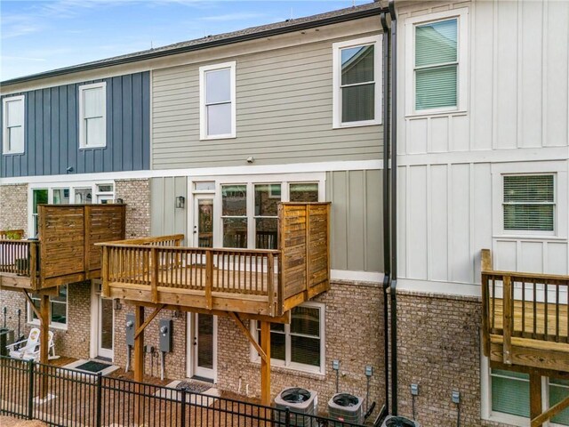 rear view of house featuring central AC and a wooden deck