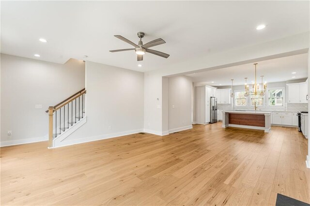 kitchen with light hardwood / wood-style floors, a center island, decorative light fixtures, and stainless steel appliances