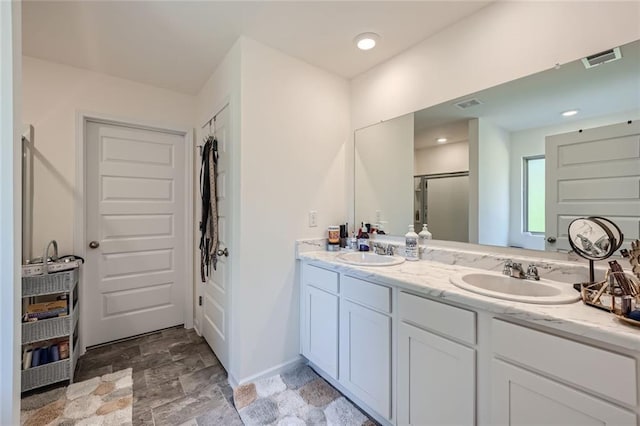 bathroom featuring vanity and a shower with shower door