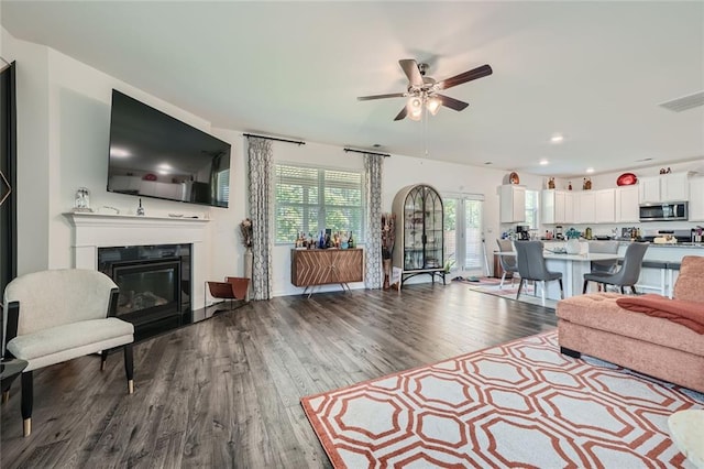 living room featuring wood-type flooring and ceiling fan