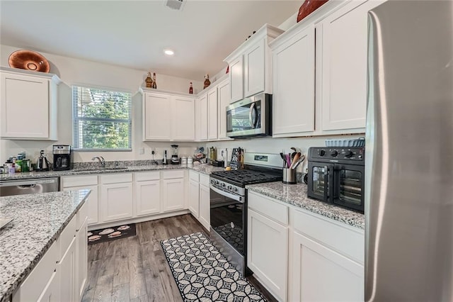 kitchen featuring white cabinetry, sink, dark wood-type flooring, and appliances with stainless steel finishes