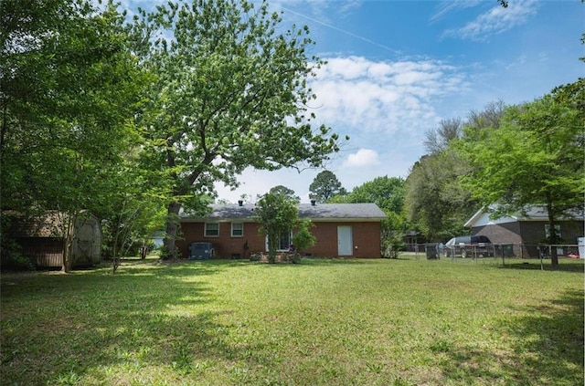 view of yard with an outbuilding, a storage unit, and fence