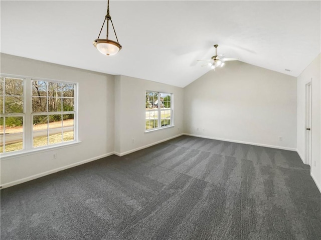 interior space featuring baseboards, a ceiling fan, dark carpet, and lofted ceiling
