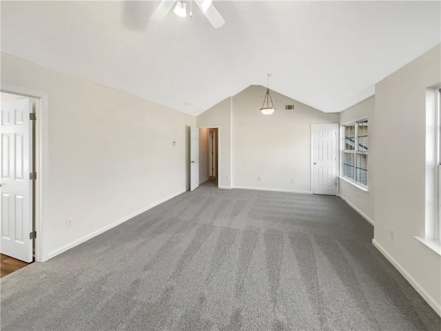 carpeted empty room featuring baseboards, ceiling fan, visible vents, and lofted ceiling