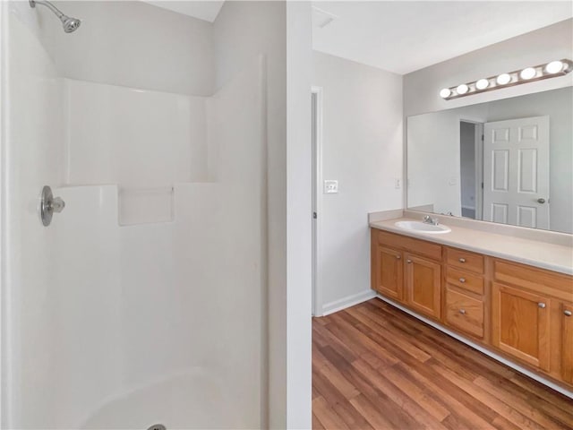 full bathroom featuring vanity, walk in shower, and wood finished floors