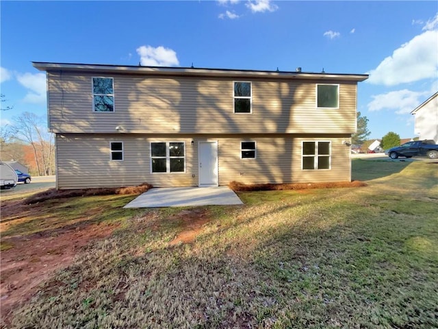 back of house featuring a lawn and a patio