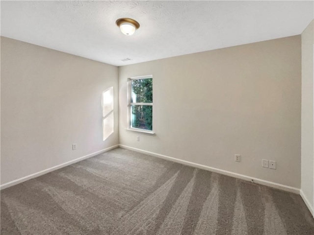 carpeted spare room featuring baseboards