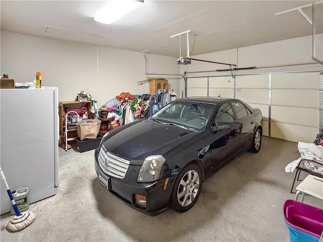 garage featuring a garage door opener and freestanding refrigerator