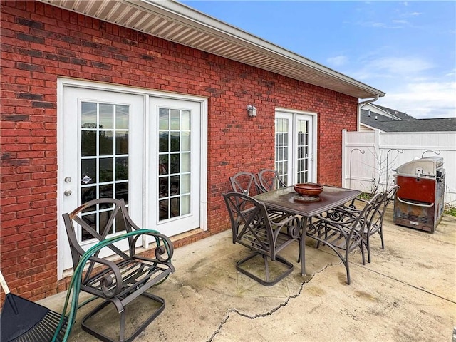 view of patio / terrace featuring outdoor dining space, french doors, and fence