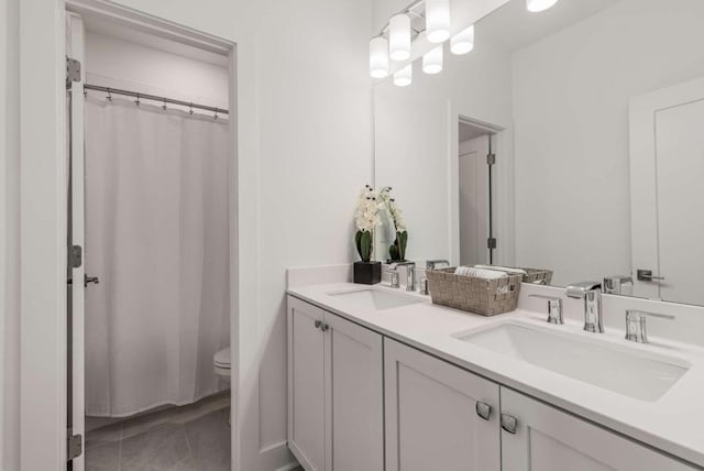 full bath featuring a shower with curtain, a sink, toilet, and double vanity