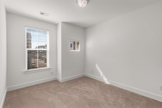 spare room with visible vents, baseboards, and carpet flooring