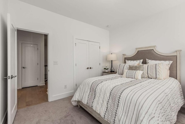 carpeted bedroom featuring baseboards and a closet