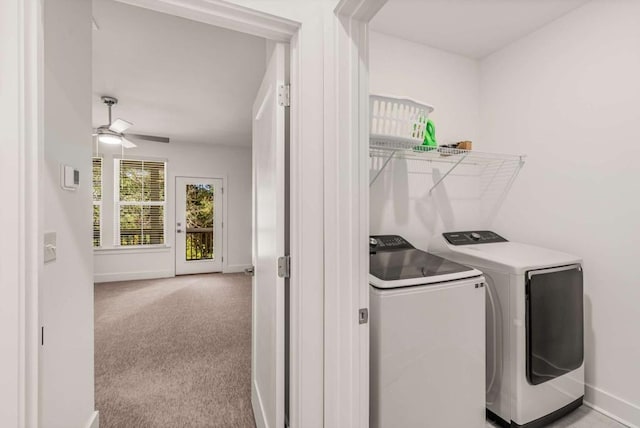 washroom with ceiling fan, baseboards, light colored carpet, and washing machine and clothes dryer