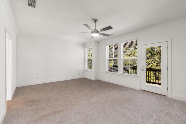 carpeted spare room with visible vents, ceiling fan, and baseboards