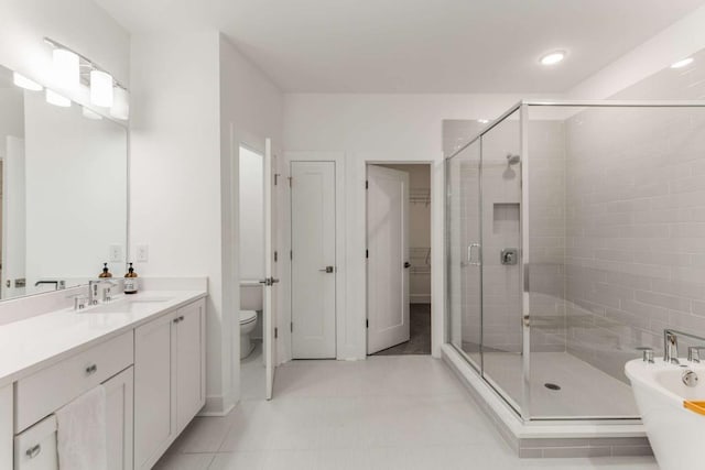 bathroom with toilet, a stall shower, a freestanding tub, and vanity