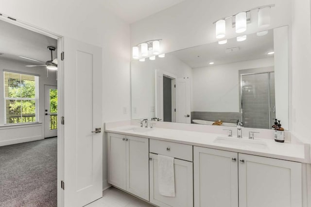 full bathroom featuring ceiling fan, a sink, a shower stall, and double vanity