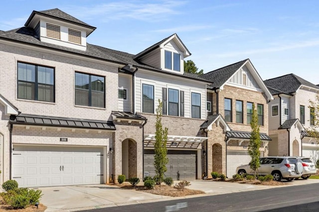 view of property featuring brick siding, concrete driveway, an attached garage, a standing seam roof, and metal roof