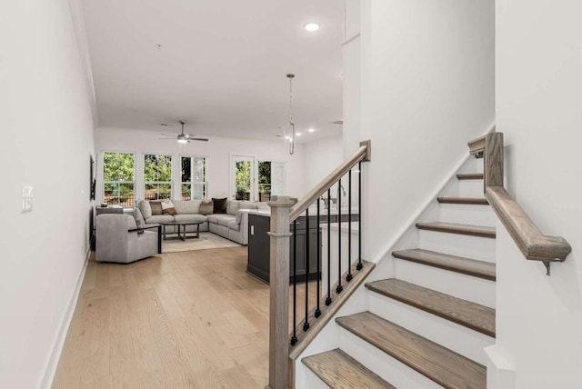 staircase featuring recessed lighting, ceiling fan, baseboards, and wood finished floors