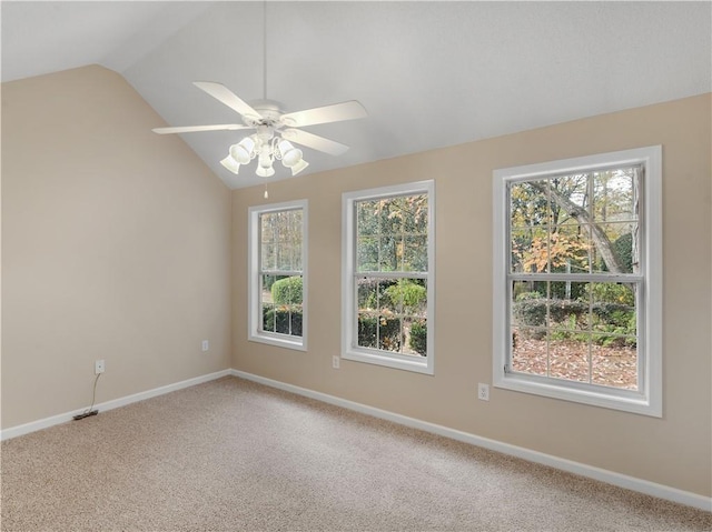 carpeted spare room with lofted ceiling, a ceiling fan, and baseboards