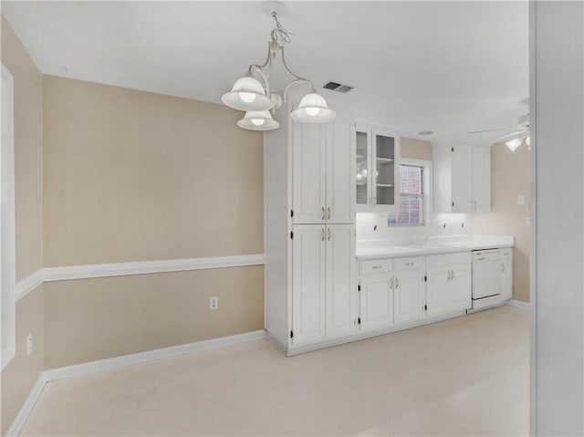 kitchen featuring dishwasher, light countertops, glass insert cabinets, and white cabinetry