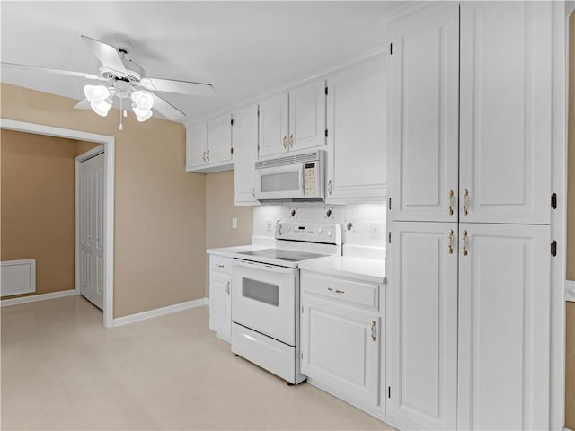 kitchen featuring light countertops, white cabinets, ceiling fan, white appliances, and baseboards