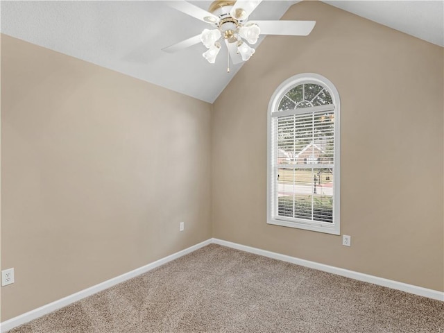 carpeted spare room featuring vaulted ceiling, baseboards, and ceiling fan