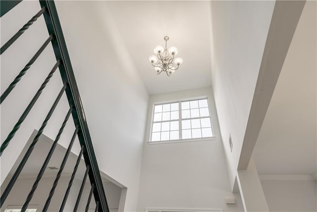 stairs with an inviting chandelier and a high ceiling