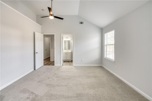 unfurnished bedroom with visible vents, connected bathroom, baseboards, carpet, and vaulted ceiling