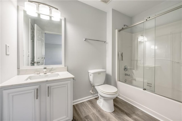 full bath with baseboards, toilet, wood finished floors, enclosed tub / shower combo, and vanity