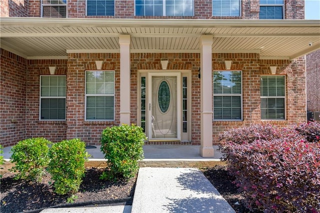 view of exterior entry featuring covered porch