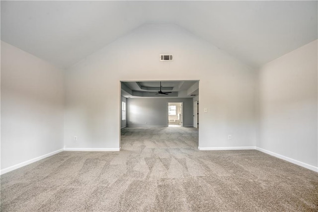 carpeted empty room with visible vents, baseboards, a raised ceiling, and ceiling fan