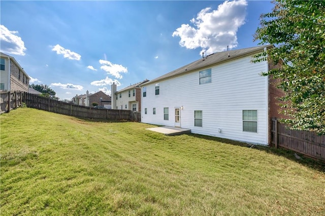 back of property with a lawn, a patio, and a fenced backyard