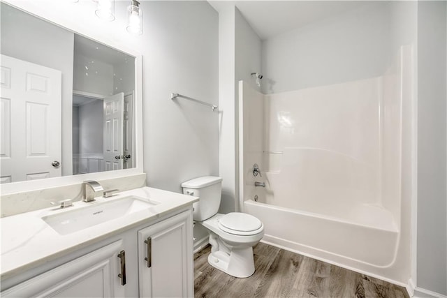 bathroom featuring shower / bathing tub combination, toilet, wood finished floors, and vanity