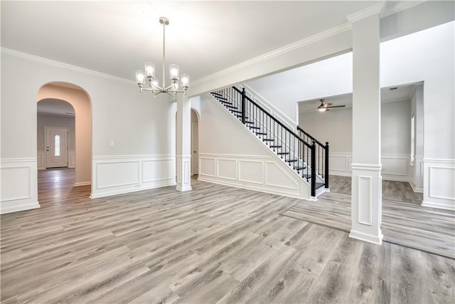 interior space featuring arched walkways, stairway, light wood-type flooring, and ornamental molding