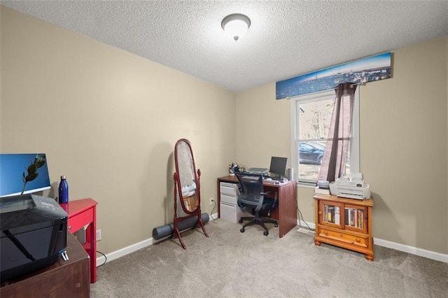 carpeted office featuring a textured ceiling