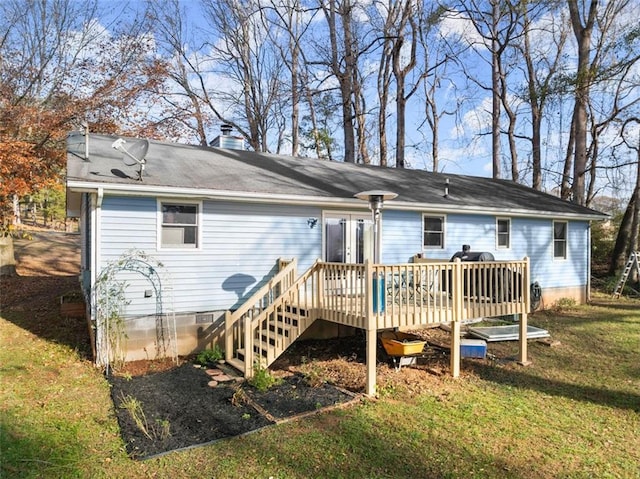 rear view of house featuring a lawn and a wooden deck