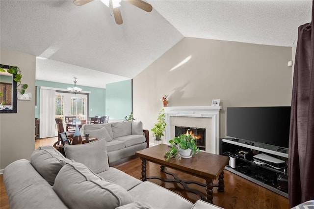 living room featuring a textured ceiling, ceiling fan with notable chandelier, light hardwood / wood-style floors, and lofted ceiling