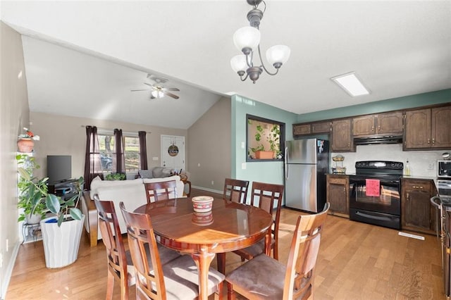 dining room featuring ceiling fan with notable chandelier, light hardwood / wood-style floors, and vaulted ceiling