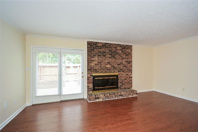 unfurnished living room featuring a brick fireplace, ornamental molding, dark hardwood / wood-style floors, and a healthy amount of sunlight