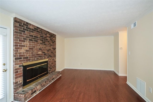 unfurnished living room with crown molding, a brick fireplace, a textured ceiling, and dark hardwood / wood-style flooring