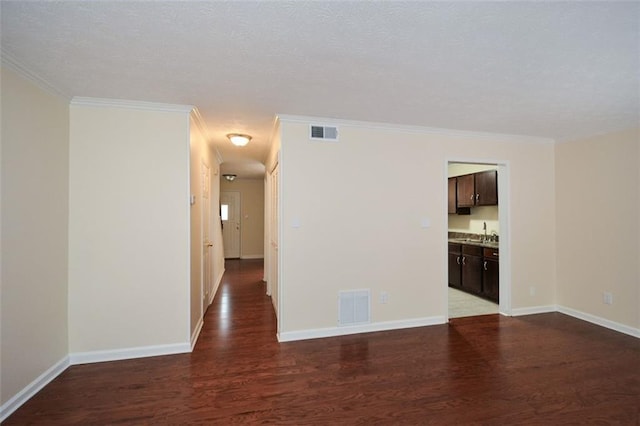 empty room with crown molding, sink, and hardwood / wood-style flooring