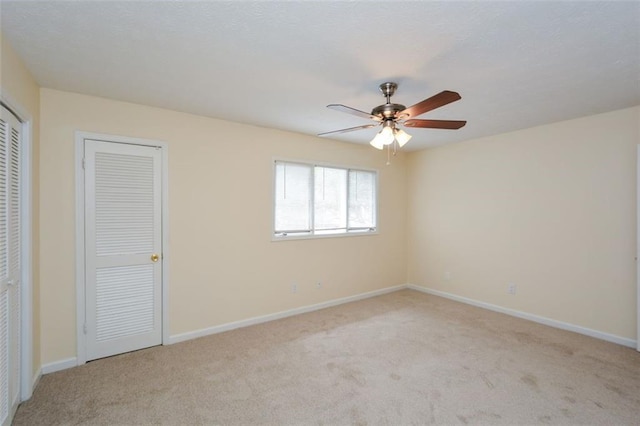 unfurnished room with light colored carpet and ceiling fan