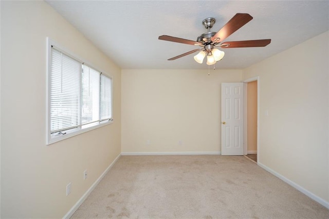 spare room featuring light colored carpet and ceiling fan