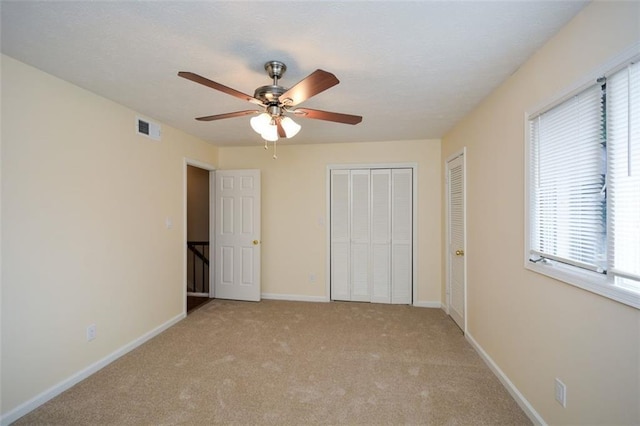 unfurnished bedroom featuring ceiling fan and light carpet